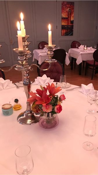gedeckter Tisch mit Kerzenhalter und Blumenschmuck bei Ben - das Restaurant